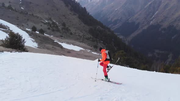 An Aerial-looking Skier in an Orange Suit Makes a Kicker Jump in the Spring When There Is Little