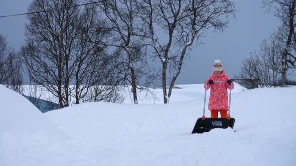 Child Girl Helping To Clean A Pathway From Snow