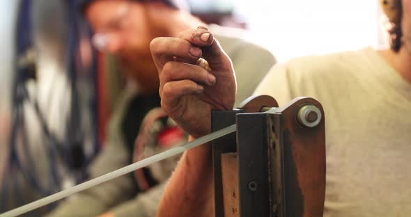 Bladesmith deburring a blade on belt grinder