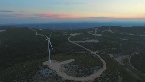 Aerial view of nine windmills for the production of electric energy, at sunset