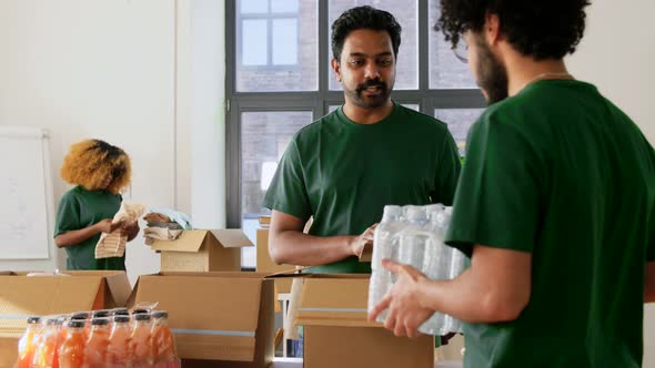 Group of Volunteers Packing Food in Donation Boxes