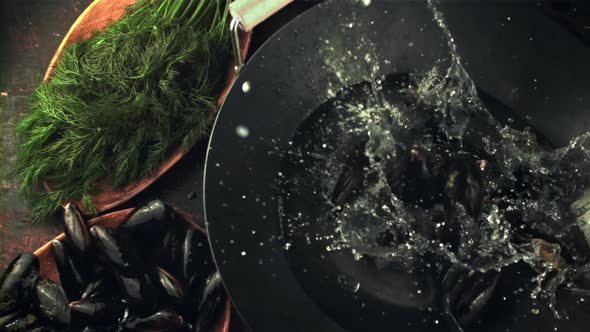 Super Slow Motion with Splashes Fall Into a Pan with Mussel Water