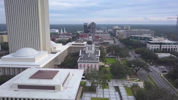 Flag waves atop Old Capitol building with New Capitol just behind in downtown Tallahassee, Florida.