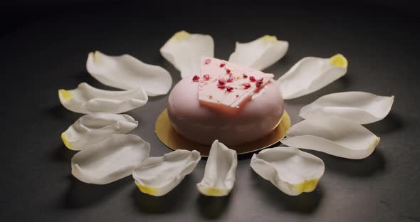 Shot of Tasty Sweet Round Dessert with Pink Cream and White Flower Petals