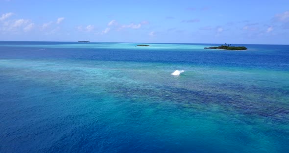 Wide angle overhead abstract view of a paradise sunny white sand beach and blue water background 