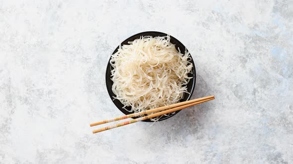 Close Up of Bowl of Noodles with Wooden Chopsticks