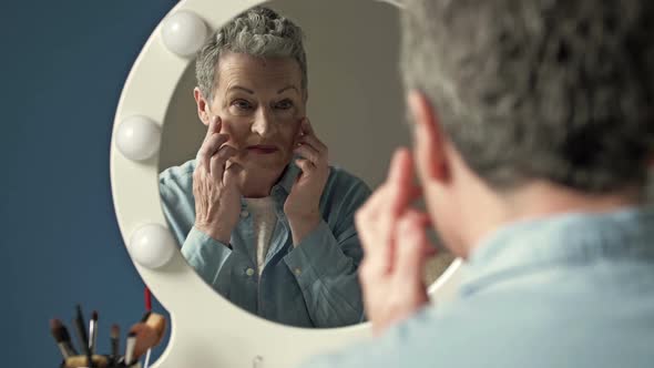 An Elderly Woman Applies an Antiaging Moisturizer