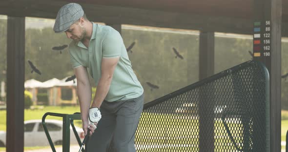 Young Concentrated Man Hitting Ball with Iron, Playing Golf at Private Club