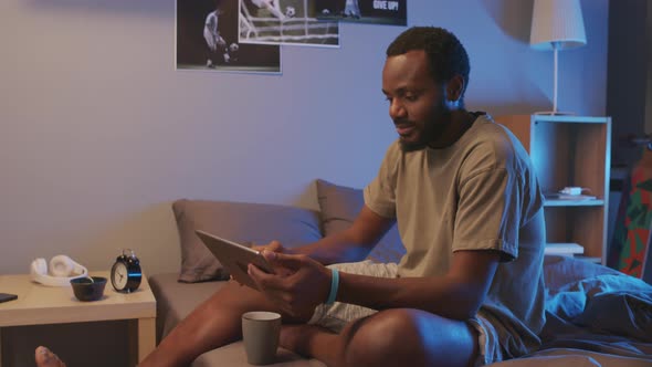 Man Watching TV on Tablet Computer