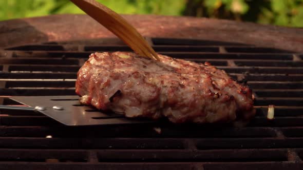 Close-up View of the Delicious Burger Cutlet Flipped on the Grill with a Spatula