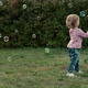 Little Baby Girl Plays with Soap Bubbles and Laughs Outdoors in Summer Park - VideoHive Item for Sale