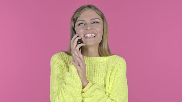 Happy Young Girl Talking on Phone Pink Background