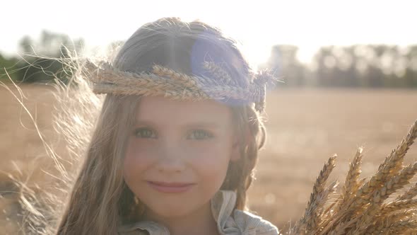 Serious Sad Girl a Child Stands on a Wheat Mown Field