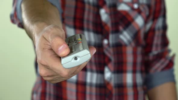 Man Holds in Hands Black Remote Control Television Changing One Channel. Close Up