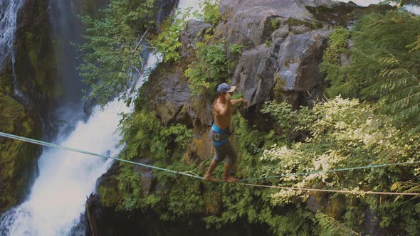 Fit Man High-lining Over A Waterfall