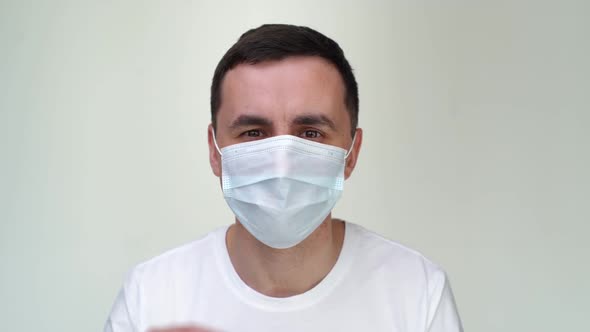 Joyful Young Happy Man Taking Off Medical Mask and Looking at the Camera.