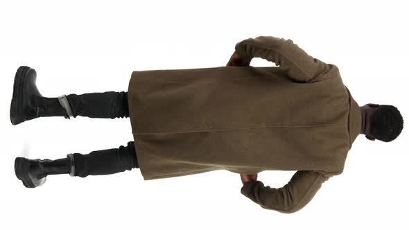 AfroAmerican Man Pulls Hands Out the Pockets of Brown Coat Shot From the Back Over White Background
