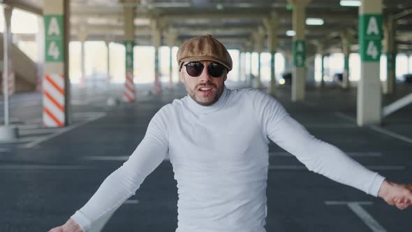 Cheerful and Happy Young Man with Beard Actively Is Dancing While Walking Down the Street on Urban