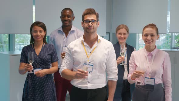 Slider Shot of Multiethnic Team Looking at Camera and Raising Glass Wit Champagne