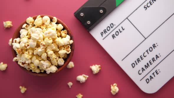 Movie Clapper Board and Popcorn on Red Background