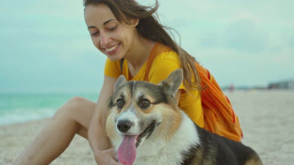 Attractive Young Woman Smiling and Spending Time Together with Her Pet Cute Corgi Dog Outdoors at