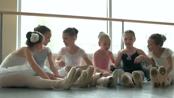 Cute Little Ballerinas Resting on the Floor