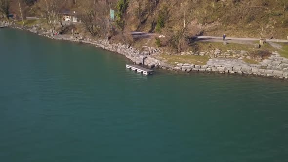 The drone orbits around a raft on the lake of Walen in Switzerland. In the background are some peopl