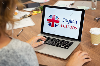  at office. Laptop screen of woman displaying english lessons poster with British flag. Closeup of student using laptop doing online course on english.