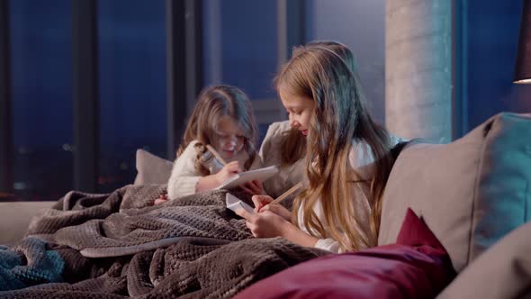 Mother Painting with Daughters in Album on Couch