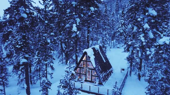 Little Hut in Mountain Covered with Snow. Flying with Drone Over the Forest and Beautiful Chalet.