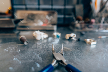 rom a close angle Jewelry repair shop. Tools, unfinished silverware and rough stones.