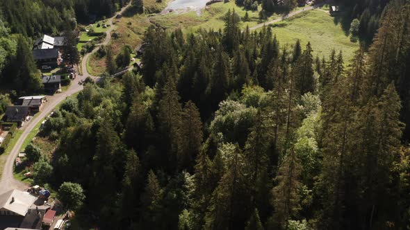 Jib down of tree tops with a stunning lake and beautiful mountainside in background