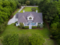 Aerial view of large home with new roof on wooded grassy propert - PhotoDune Item for Sale