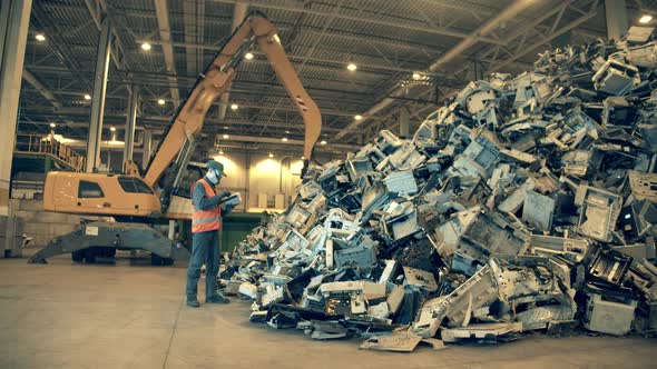 Landfill Worker Is Inspecting a Pile of Rubbish