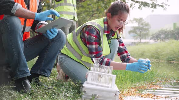 Scientist woman collecting samples of factory wastewater in a test tube