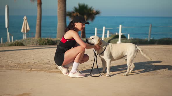 Side View Young Woman Stroking White Dog at Background of Picturesque Cyprus Landscape