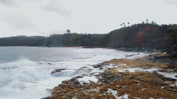 Aerial drone moves quickly along the rocky coastline of Kauai, Hawaii, USA