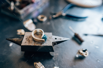 rom a close angle Jewelry repair shop. Tools, unfinished silverware and rough stones.
