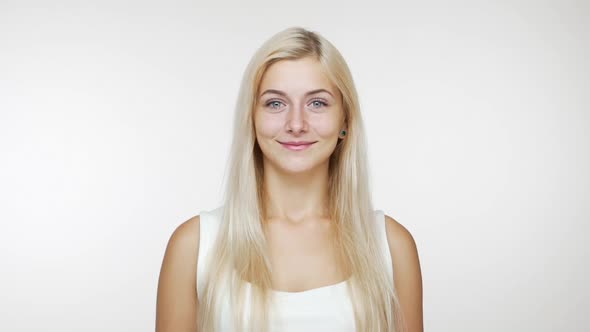 Caucasian Woman with Long Blond Hair Laughing Out Loud Covering Her Mouth with Hands Giggling Over