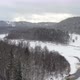 Aerial Drone flight over snowy frozen river in mountain forest valley of Sigulda, Latvia - VideoHive Item for Sale