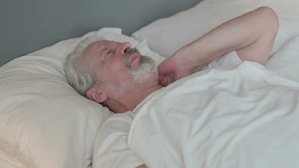 Exhausted Old Man with Neck Pain in Bed