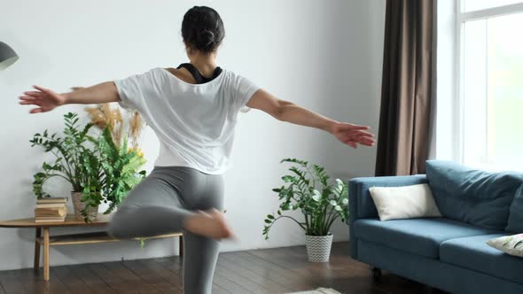 A young Indian Woman trains at home, Does a Spinning exercise, Bright Cozy Room