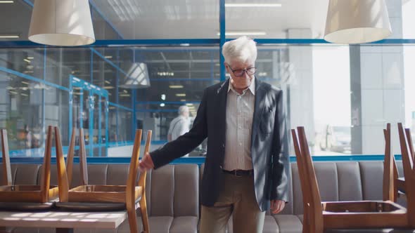 Sad Senior Small Business Owner Walking in Empty Cafe Closed Because of Quarantine