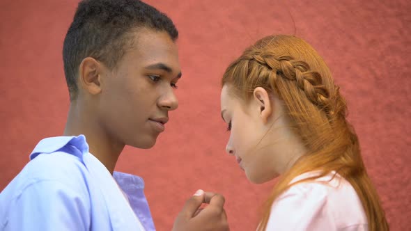 Mixed-Race Boyfriend Tenderly Holding Girlfriends Chin, Moment of First Kiss