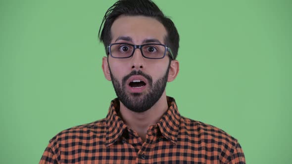 Face of Young Bearded Persian Hipster Man Looking Shocked