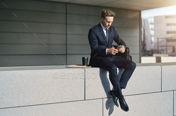 Confident stylish businnessman sitting with his phone