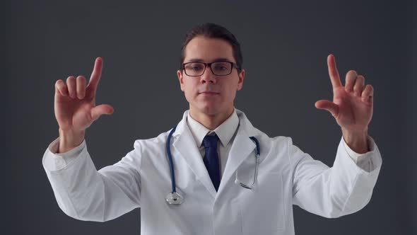 Studio portrait of young professional medical doctor standing over grey background