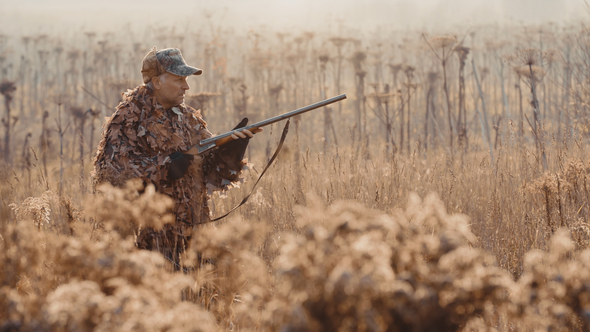 Hunter in Hunting Equipment With a Rifle in His Hands