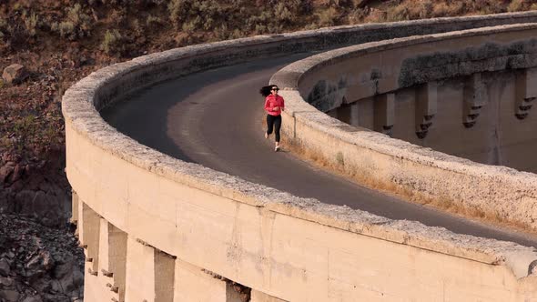 Asian woman jogging across the Salmon Falls Dam in Idaho