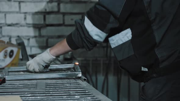 Man Worker in Protective Helmet Welding the Details